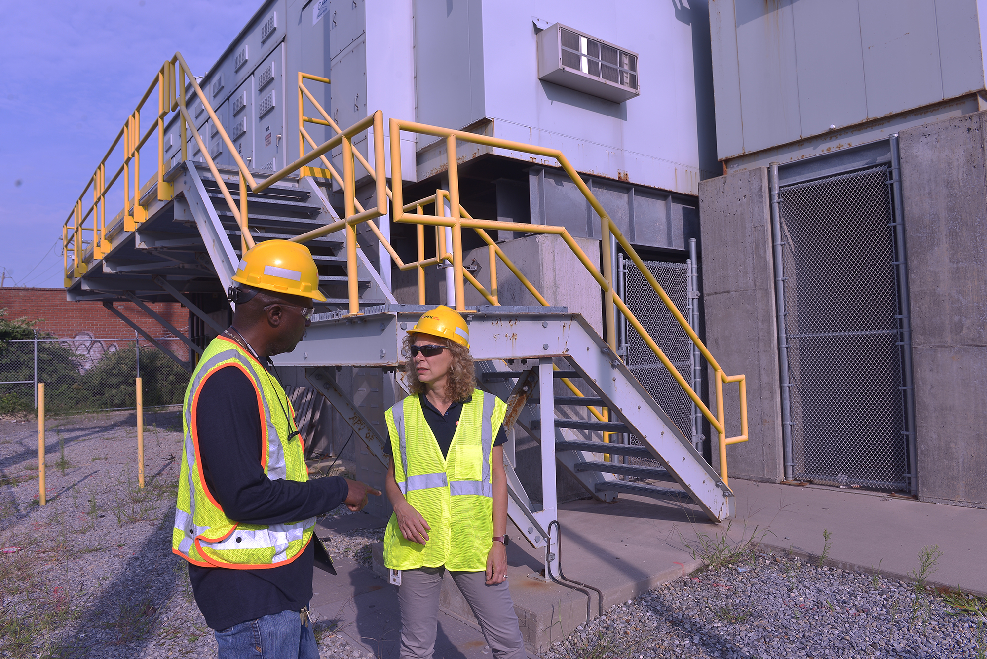 PSEG Long Island employees confer in front of substation equipment that has been elevated as part of the company's ongoing efforts to address the increasing frequency and severity of extreme weather events.